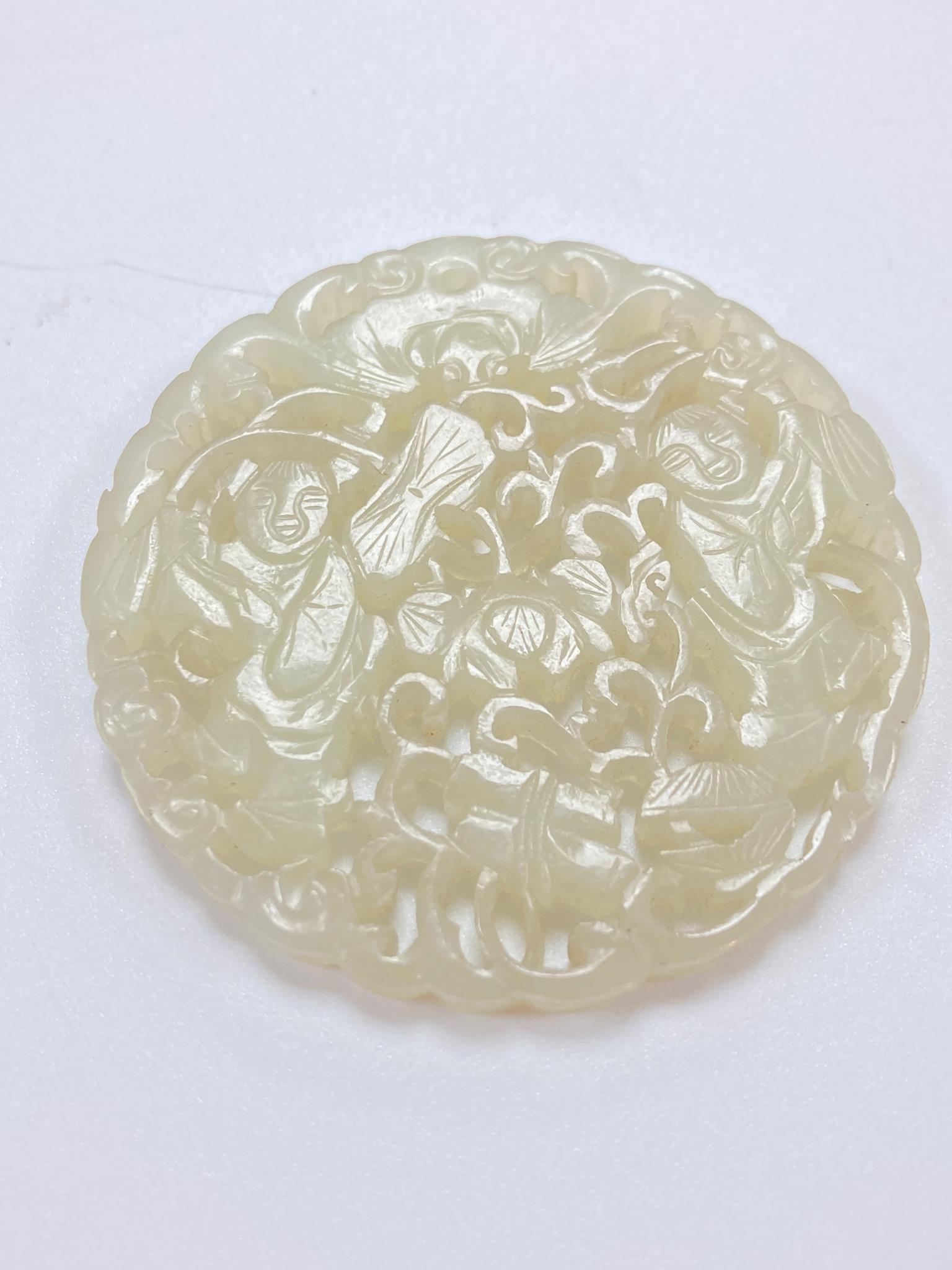 A Chinese white jade ‘Hehe Erxian’ disc, 19th/20th century, 5.6cm diameter, wood stand